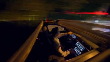 Yetenekli bir sürücü, gece hareketli bir şehirde, gelişmiş teknolojiyle şık bir iç mekan sergiliyor.