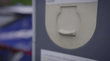 Kamu Şarj İstasyonundaki Şarj Edici Elektrikli Aracın Kablo Bağlantısı kullanarak detaylı ve yakın plan bir görüntüsü. 