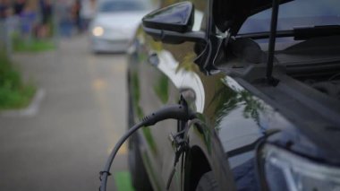 Şık, modern bir elektrikli araç ileri ve yenilikçi bir şarj istasyonunda şarj ediliyor.