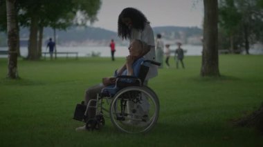 Huzurlu bir park ortamında bireyler arasında paylaşılan bakım ve bağlantıyı güzel bir şekilde tasvir eden huzurlu bir an.