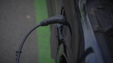 Detaylı bir görüntüde bir elektrikli aracın şarj kablosu gösteriliyor.