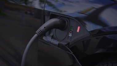 Araçtaki limana güvenli bir şekilde bağlı olan bir elektrikli aracın yakın çekim görüntüsü