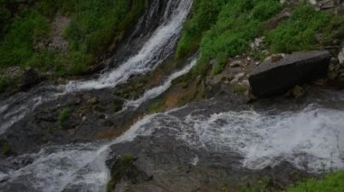 Bereketli yeşilliklerle çevrili kayaların üzerinden akan sakin bir dağ akıntısı huzurlu bir atmosfer yaratıyor..