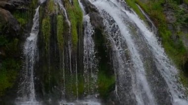 Nefes kesen güzellikte bir şelale, bereketli kayaların üzerinde zarif bir şekilde akar.