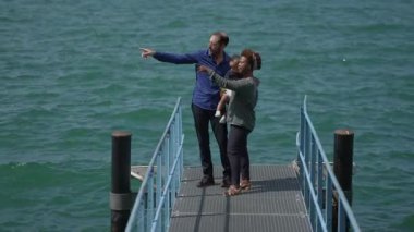 Yaz tatilinde erkek bebeğe bakan çok ırklı aileler.