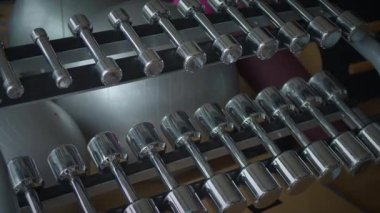 Pek çok insanın eğitim gördüğü canlı bir spor salonunda organize edilmiş bir halterin yakın çekimi.