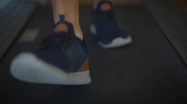 Koşu bandında hızla koşan enerjik ayaklar canlı ve aktif bir yaşam tarzının özünü gözler önüne seriyor.