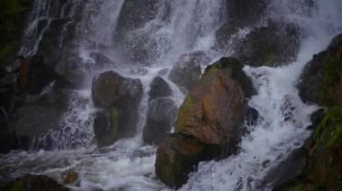 Uçsuz bucaksız kayaların üzerinde çağlayan bir şelalenin nefes kesici manzarası, büyüleyici güzellikleri yakalıyor.