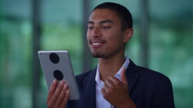 Akıllı takım elbiseli genç profesyonel bir adam dijital çağda bir tablet kullanır, teknoloji ve iletişim becerileri sergiler.