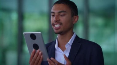 Genç bir profesyonel şık ve modern bir tablet kullanıyor. Gelişmiş teknolojiyi şık bir ortamda sergiliyor.