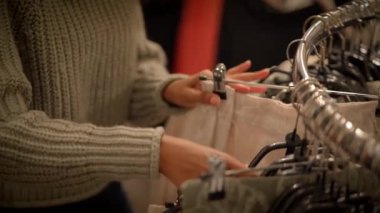 Modern moda bir perakende mağazasında alışveriş yapan biri şık giyim seçeneklerini gözden geçirir.