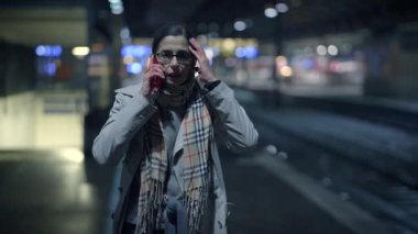 Endişeli bir birey, loş bir tren istasyonunda yalnız başına duruyor. Derin stres ve aciliyeti somutlaştırıyor.