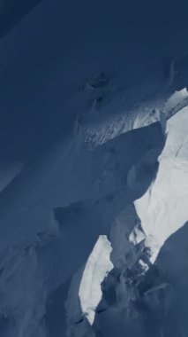 Karlı dağların nefes kesici manzarası, kış manzaralarının çarpıcı ve büyüleyici güzelliğini canlı bir şekilde yakalıyor.
