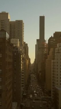 Büyüleyici şehir silüeti gün batımında güzelce aydınlatılıyor, yüksek binalar ve işlek caddeler sergileniyor.