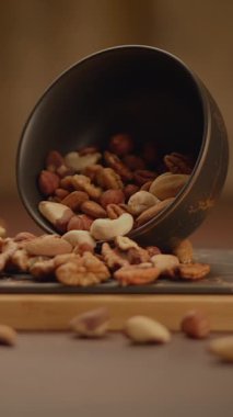 Bir fotoğrafta zarif bir kaseden dökülen fındıkların dokuları ve renkleri vurgulanıyor.