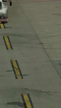 Sarı çizgiler ve çeşitli desenler gösteren bir pist yüzeyinin detaylı bir yakın çekimi