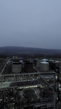Büyük depolama tanklarının karamsar, bulutlu bir manzaradaki hava görüntüsü, endüstriyel tesisleri gösteriyor..