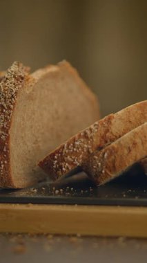 Köy ahşap bir tahtaya yerleştirilmiş güzel dilimlenmiş tahıllı ekmeğin yakın plan fotoğrafı. Mutfak için ideal.