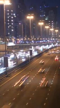 Canlı şehir trafiğini gösteren nefes kesici bir gece manzarası. Parlayan sokak lambalarıyla güzelce aydınlatılıyor.