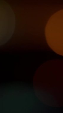 Hafifçe bulanık turuncu kürelerin büyüleyici etkileşimi derin ve karanlık bir arkaplanda güzel bir tezat oluşturuyor.