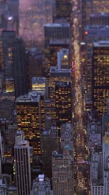 Manhattan 'ın göz kamaştırıcı hava manzarası alacakaranlıkta güzelce aydınlatılıyor, canlı şehir ışıklarını vurguluyor.