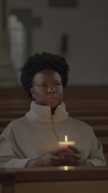 Huzurlu bir birey, huzurlu bir kilisede sessizce parlayan bir mum tutar, derin bir huzur ve yansımayı somutlaştırır.