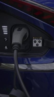 Elektrikli araç şarj portunun yakın görüntüsü, konnektörü şarj etmek için uygun pozisyonda gösterir