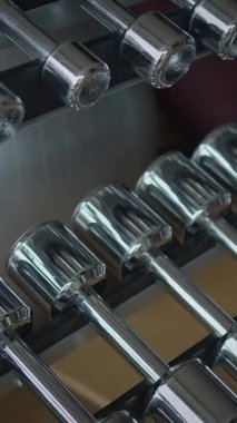 Bu krom halterlerin düzgün ve çekici bir spor salonundaki detaylı ve dikkatlice düzenlenmiş görüntüsü.