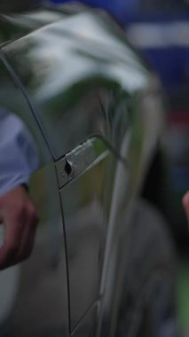Arabanın kapı koluna uzanan bir eli gösteren yakın plan bir görüntü, hem erişim hem de kolaylığı temsil ediyor.