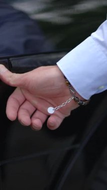 Zarif bir el, zarif bir gömlekle moda bilezikleri sergiliyor. Modadan ilham almak için mükemmel.