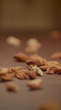 Kırsal ahşap bir yüzeye sanatsal olarak dağılmış çeşitli çiğ fındık koleksiyonu.