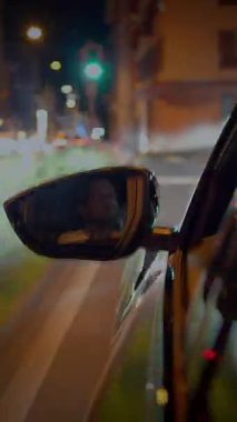 Çarpıcı bir şekilde büyüleyici bir görüntü yakalanıyor, bir arabanın gece dikiz aynasından geçen dinamik hareketini gösteriyor.