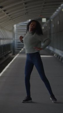 Bir kadın yoğun bir modern ulaşım istasyonunda enerjik bir şekilde koşuyor, kentsel yaşamı ve hareketi somutlaştırıyor.