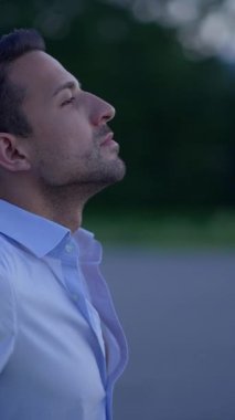 Düşünceli bir adam, sakin ve huzurlu bir açık hava ortamının içindeki mesafeye dikkatlice bakar.