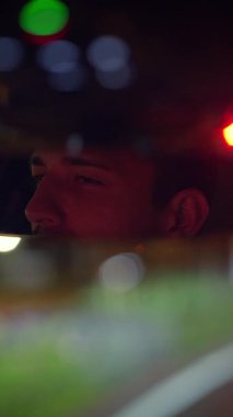 Düşünceli bir sürücü, büyüleyici şehir ışıklarına dalmış aynada güzelce yansıyan.