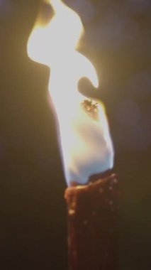 Yakından bakınca tek bir mum yanıp sönen bir alev etrafındaki karanlığı aydınlatan sıcak bir parıltı saçıyor.