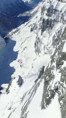 Karla kaplı dağların ve buzul oluşumlarının olduğu nefes kesici bir hava manzarası.