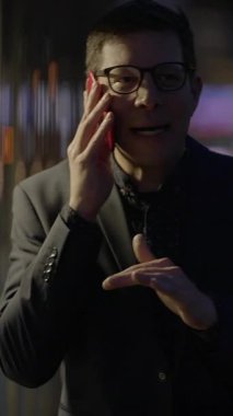 Akıllı takım elbiseli odaklanmış bir birey, profesyonel bir ortam olduğunu gösteren bir telefon görüşmesi yapar.