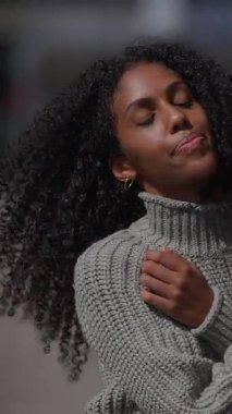 Genç bir kadın güneşin sıcaklığını sakin bir gülümsemeyle kucaklıyor, mutluluk ve sükuneti iletiyor..