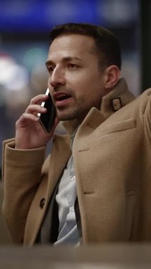 Kendini bir telefon görüşmesine adamış, modern şehir yaşamının özünü vurgulayan profesyonel bir adam.