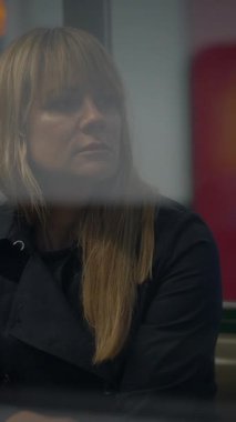 Uzun dalgalı saçları olan bir kadın, düşüncelerinde derinden kaybolan, modern çalışma alanının karmaşıklığını yansıtır.