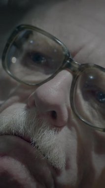 Gözlüklü yaşlı bir adamın çarpıcı ve anımsatıcı bir görüntüsü. Derin bir bilgelik ve derin bir yansıma yayıyor.