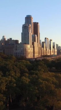 Canlı ve renkli bir günbatımına karşı nefes kesici bir kentsel ufuk çizgisi sergileniyor.