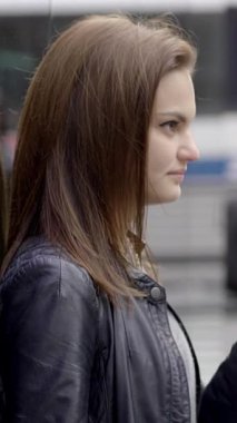 Profilde şık bir kadın, uzun saçlarını parlak deri bir ceketle sergiliyor, moda teması için mükemmel..