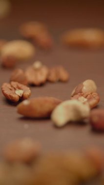 Kırsal ahşap bir yüzeye güzelce dağılmış karışık fındık çeşitlerinin yer aldığı baştan çıkarıcı bir yakın çekim.