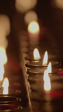 Titreyen mum alevlerinin büyüleyici bir görüntüsü, rahatlama ve yansıma için ideal sakin bir atmosfer yaratıyor.