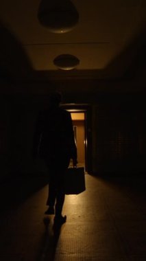 Loş ışıklı bir koridorun büyüleyici ve büyüleyici manzarası davetkar ve sıcak bir açık kapıya doğru yol alıyor.
