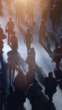 Kalabalık bir şehirde yürüyen, kaldırımda dinamik gölgeler yaratan insanların silueti.
