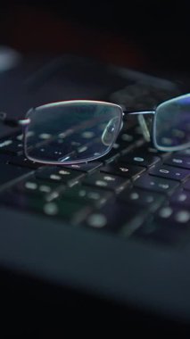 Modern bir çalışma alanındaki verimliliği sembolize eden, bir klavyenin üzerinde nazikçe dinlenen bardakların detaylı yakın plan görüntüsü