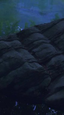 Sakinleştirici doğal bir sahne, durgun kayaların yanında, yansıtıcı su, doğa görselleri ve sanat için mükemmel.